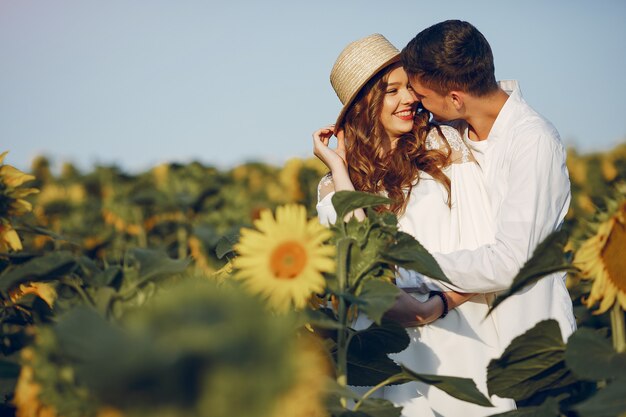 Hermosa y elegante pareja en un campo con girasoles