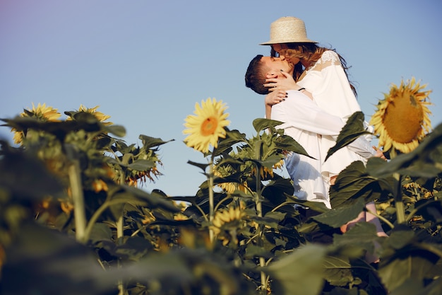 Hermosa y elegante pareja en un campo con girasoles