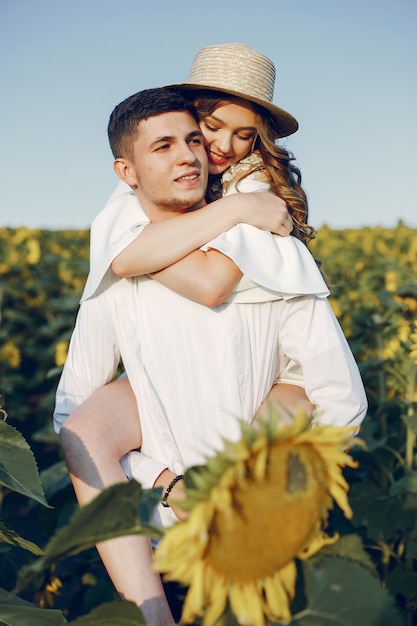 Hermosa y elegante pareja en un campo con girasoles