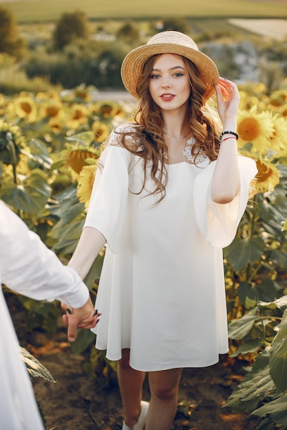 Hermosa y elegante pareja en un campo con girasoles