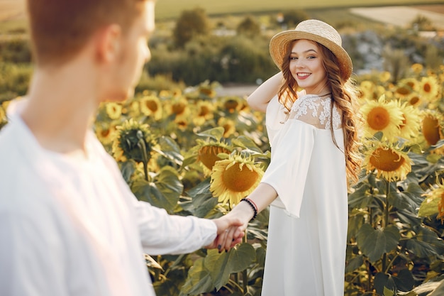 Hermosa y elegante pareja en un campo con girasoles