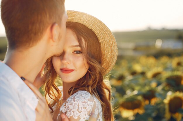 Hermosa y elegante pareja en un campo con girasoles