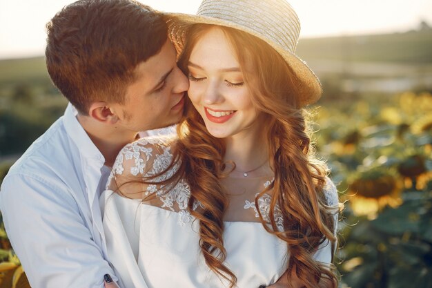 Hermosa y elegante pareja en un campo con girasoles