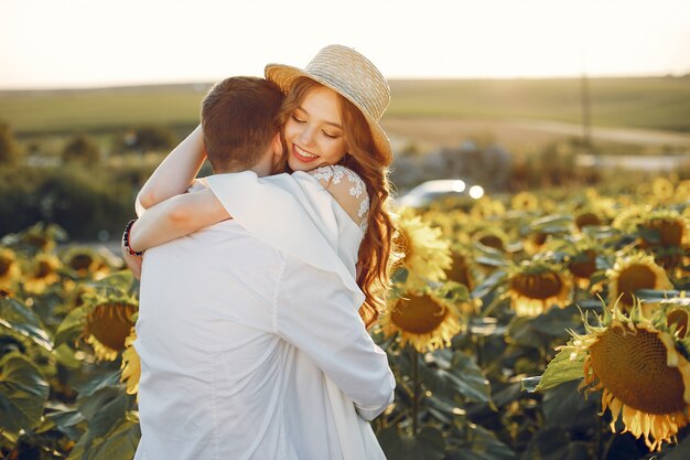 Hermosa y elegante pareja en un campo con girasoles