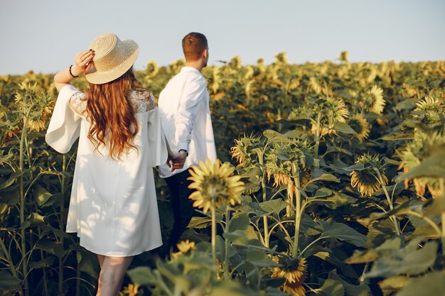 Hermosa y elegante pareja en un campo con girasoles