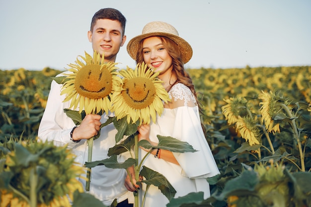 Hermosa y elegante pareja en un campo con girasoles