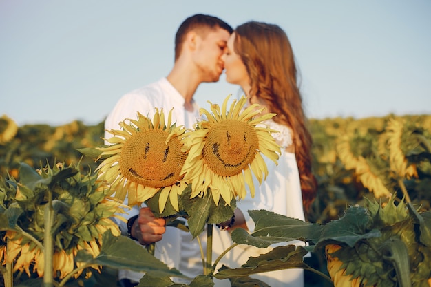 Hermosa y elegante pareja en un campo con girasoles