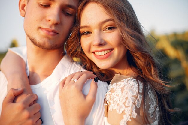 Hermosa y elegante pareja en un campo con girasoles