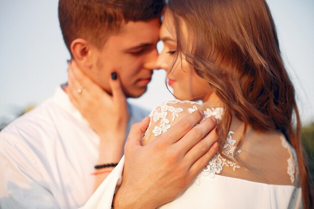 Hermosa y elegante pareja en un campo con girasoles