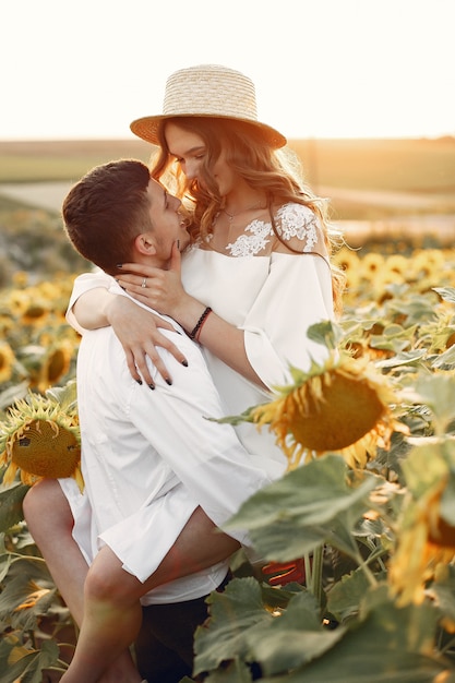 Hermosa y elegante pareja en un campo con girasoles