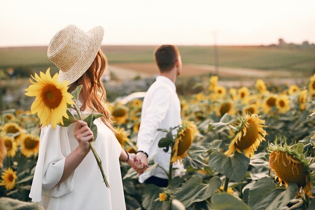 Hermosa y elegante pareja en un campo con girasoles