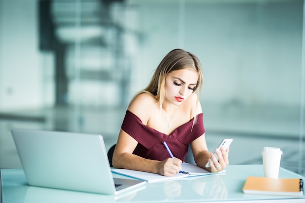 Hermosa empresaria trabajando sentado en su escritorio en la oficina