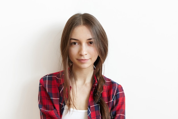 Hermosa y encantadora mujer caucásica joven con ojos marrones y cabello oscuro desordenado