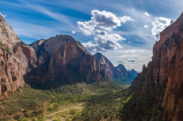 Hermosa escena de un cañón verde rodeado de rocas bajo un cielo brillante de verano