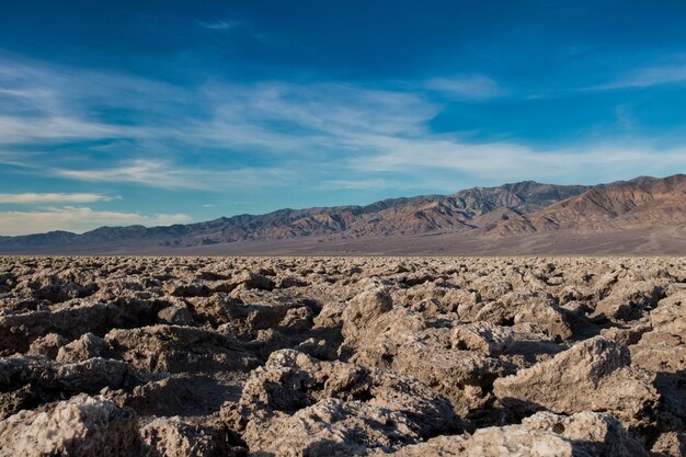 Hermosa escena de un terreno rocoso en un desierto y el cielo azul brillante en el fondo