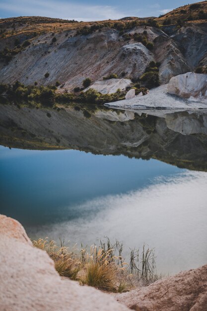 Hermosa escena vertical de un lago azul rodeado de montañas