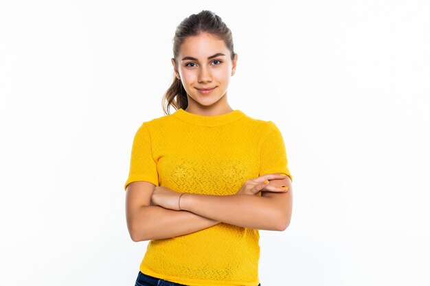 Hermosa estudiante adolescente con expresión de confianza, mantiene los brazos cruzados. Retrato de adolescente sonriente aislado en la pared blanca.