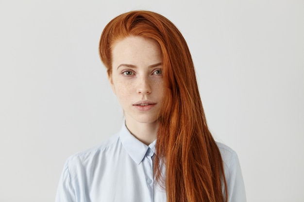 Foto gratuita hermosa estudiante pelirroja con peinado largo y suelto con camisa formal azul claro