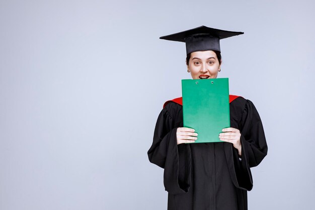 Hermosa estudiante de posgrado con diploma de pie. Foto de alta calidad