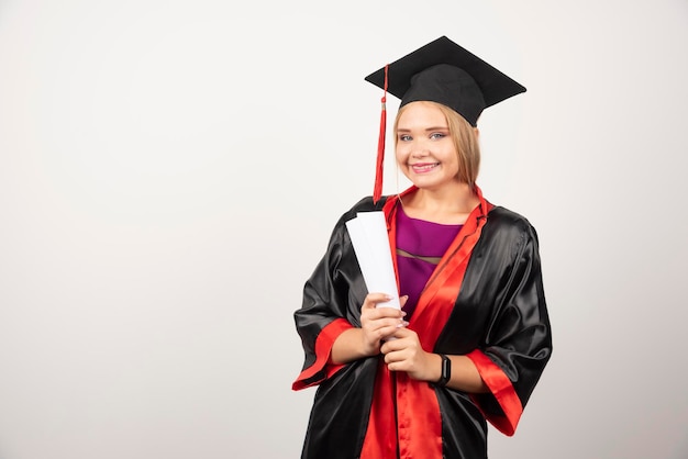 Hermosa estudiante en vestido con diploma. Foto de alta calidad