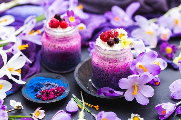 Hermosa exhibición de batidos veganos de primavera púrpura adornada con flores de colores