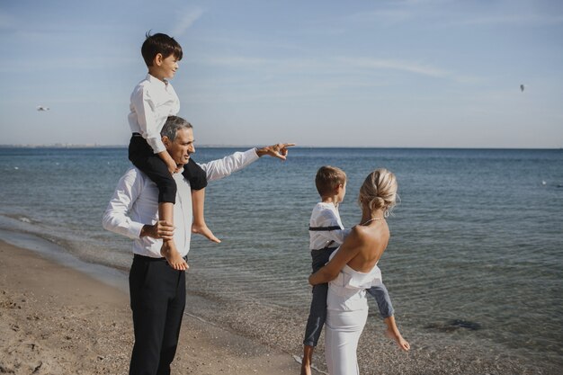 Hermosa familia está mirando el paisaje impresionante, padres y dos hijos, en el soleado día de verano