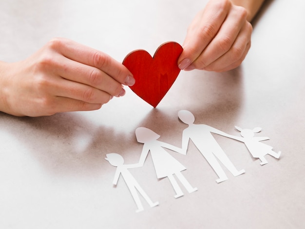 Hermosa familia de papel con un corazón de papel rojo