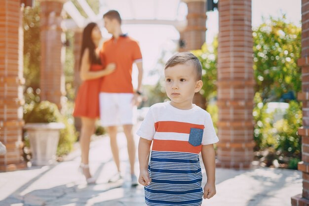 Hermosa familia en rojo caminando por la calle y el Parque