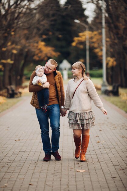 Hermosa y feliz familia con un niño pequeño en el parque