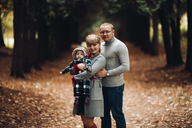 Hermosa y feliz familia con un niño pequeño en el parque