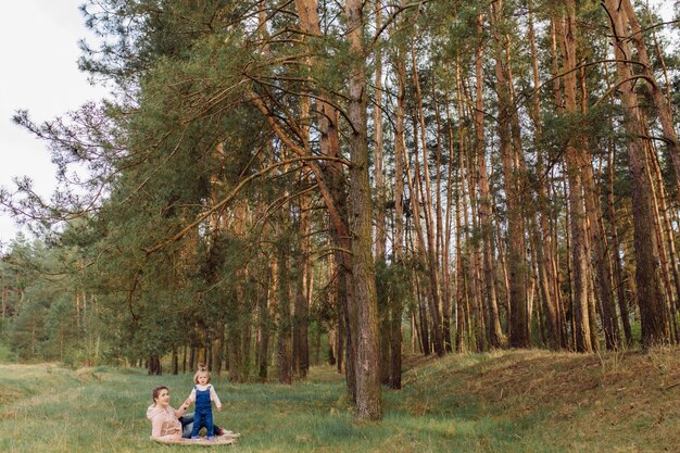 Hermosa y feliz madre e hija pasando un buen rato en el bosque