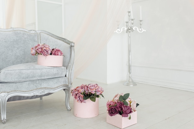 Hermosa flor beige, rosa, púrpura, peonía ramo en el piso en la caja rosa en la habitación blanca luz