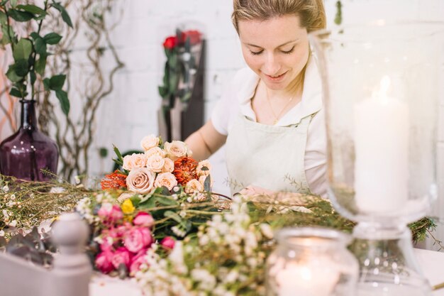 Hermosa florista en la mesa en la tienda de flores
