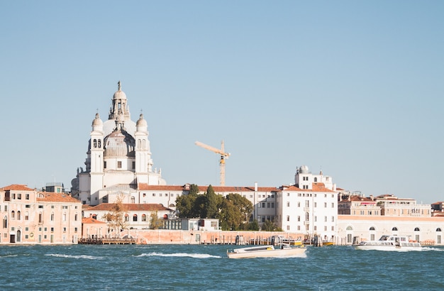 Hermosa foto de un barco en el agua y la construcción en la distancia en los canales de Venecia Italia