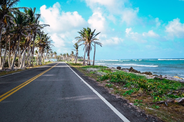 Hermosa foto de una carretera de playa con un nublado cielo azul de fondo