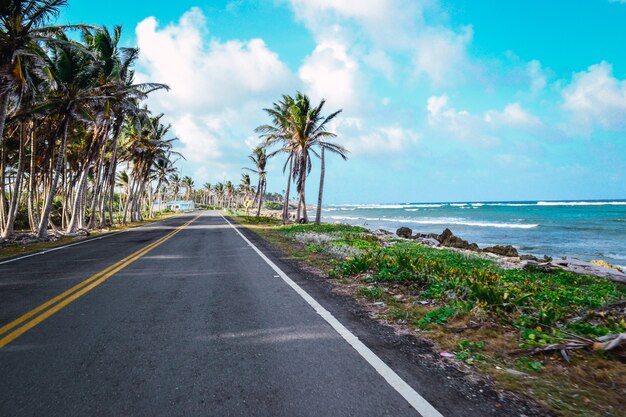 Hermosa foto de una carretera de playa con un nublado cielo azul de fondo