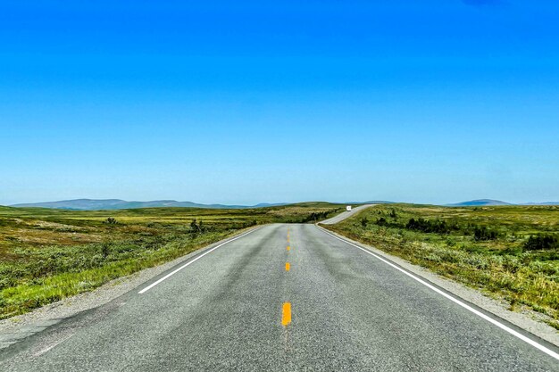 Hermosa foto de una carretera vacía bajo un cielo azul durante el día