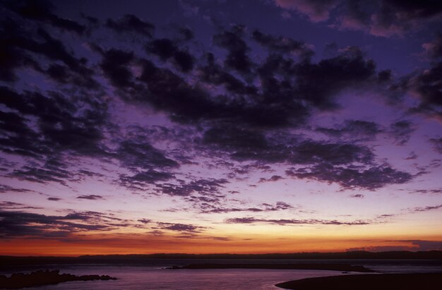 Hermosa foto de un cielo púrpura con nubes sobre el mar al atardecer