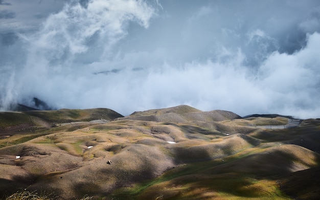 Foto gratuita hermosa foto de colinas con un cielo nublado azul de fondo