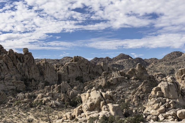 Hermosa foto de colinas rocosas y montañas bajo un cielo azul nublado durante el día