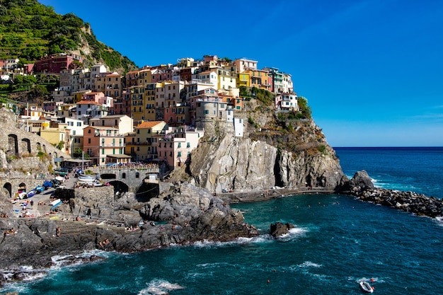 Hermosa foto de coloridos edificios de apartamentos en una colina rocosa en la orilla del mar bajo el cielo azul