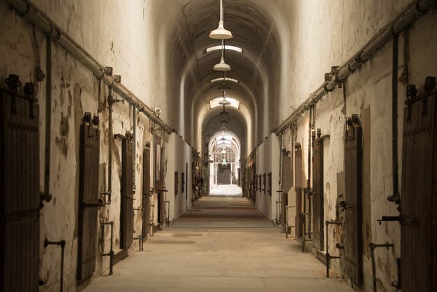 Hermosa foto de un corredor en forma de arco en un antiguo edificio abandonado con muchas puertas