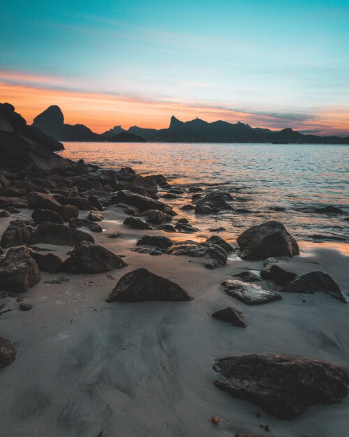 Hermosa foto de la costa rocosa del mar al atardecer con un cielo azul increíble