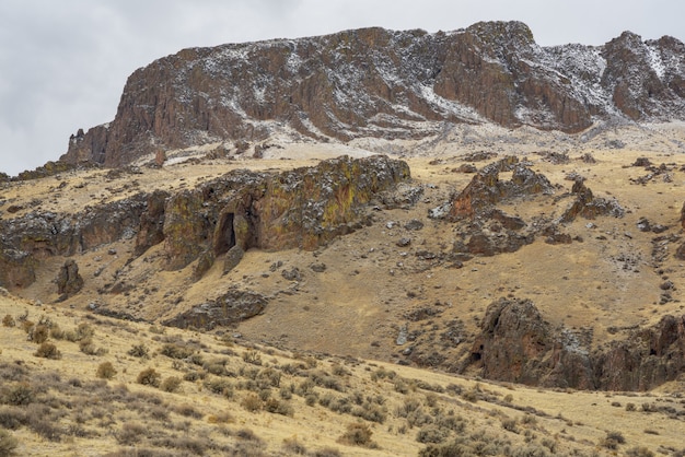 Foto gratuita hermosa foto de un desierto con una montaña nevada en la distancia y un cielo nublado