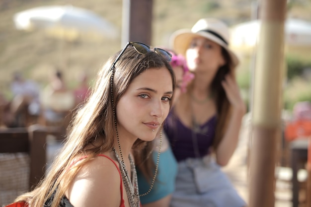 Hermosa foto de dos mujeres divirtiéndose con sombreros para el sol y gafas