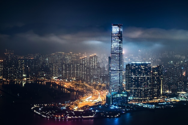 Foto gratuita hermosa foto de edificios altos de la ciudad bajo un cielo nublado por la noche