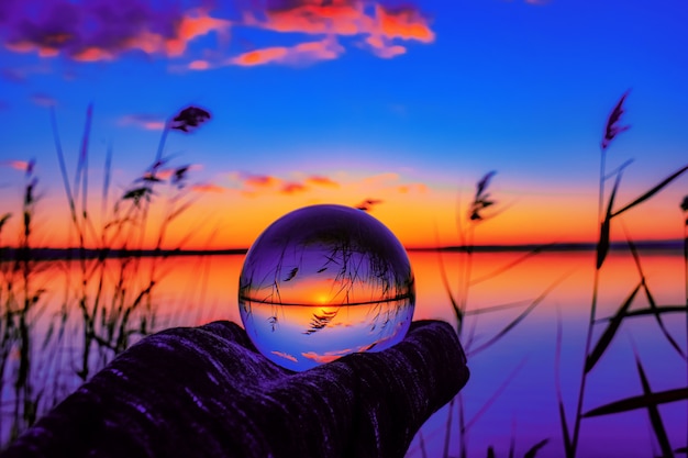 Hermosa foto de enfoque selectivo de una bola de cristal que refleja la impresionante puesta de sol