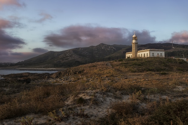 Hermosa foto del faro de Larino en una colina en Galicia España