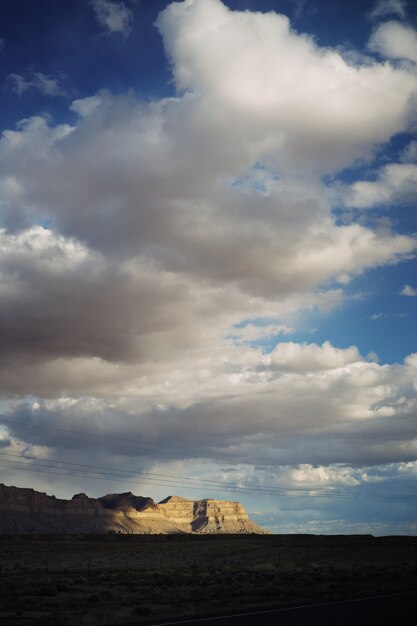 Hermosa foto de un gran desierto con nubes impresionantes y colinas rocosas