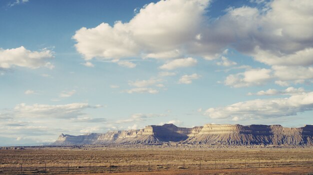 Hermosa foto de un gran desierto con nubes impresionantes y colinas rocosas